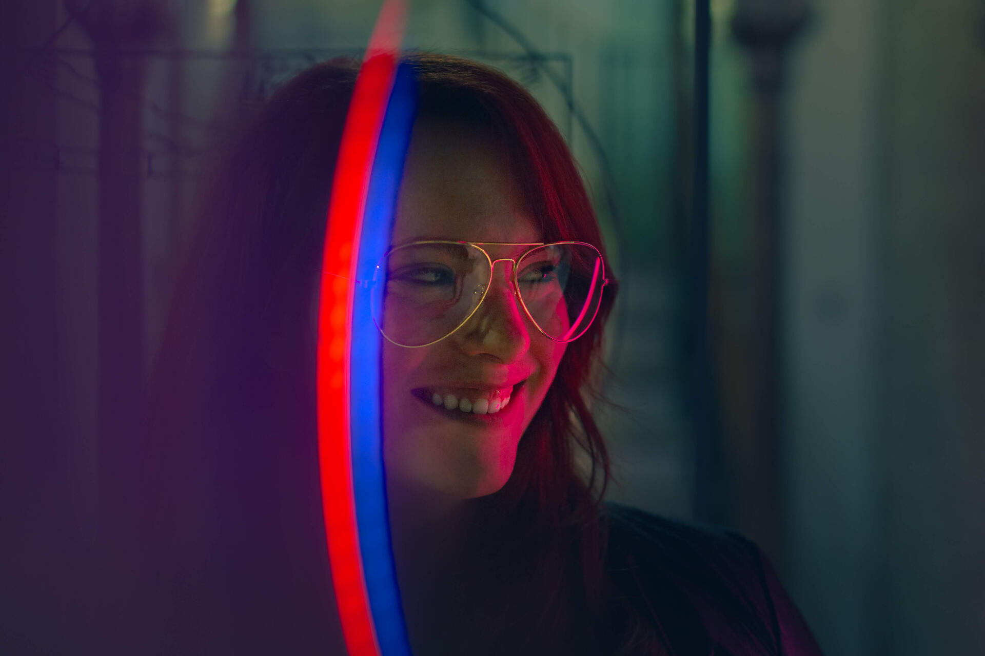 Girl with a colorful light band on her face smiling