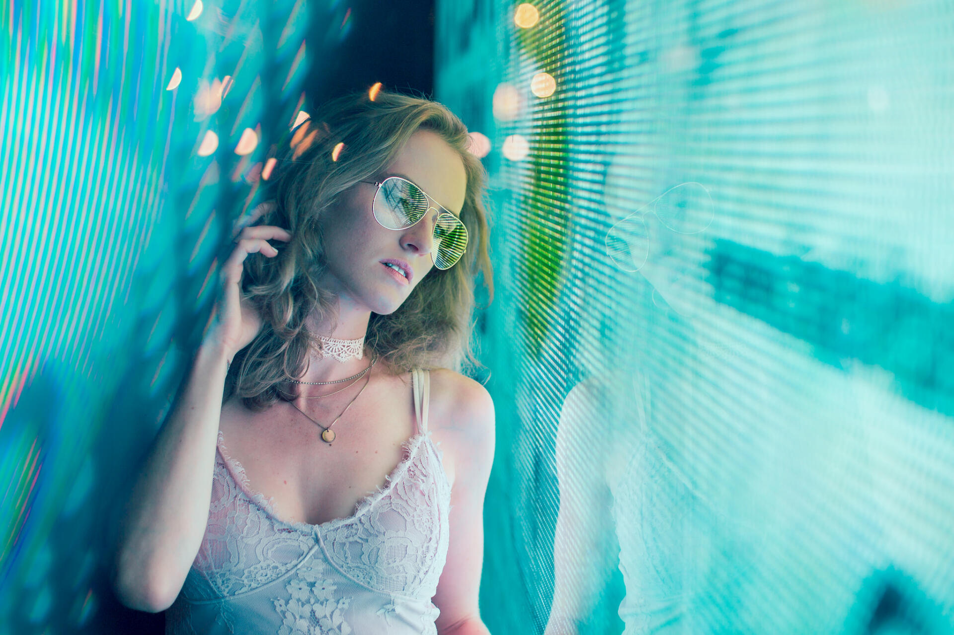 Model posing against a colorful screen with reflections 2