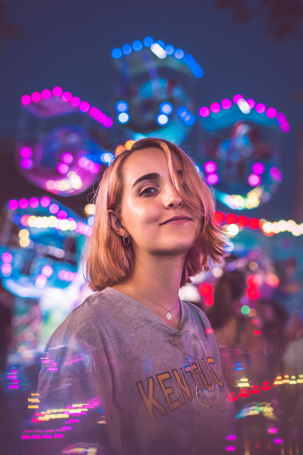 Girl in front of a ferris wheel with soft blur